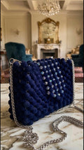 Bassmera Midnora dark navy velvet beaded shoulder bag with scattered crystal bead accents on flap, silver chain strap, angled three-quarter view showing structured rectangular silhouette and matte velvet bead texture
