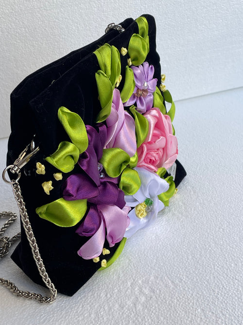Sac Bassmera Florensa en velours noir, vue latérale mettant en valeur les fleurs 3D brodées en violet, lilas, rose et blanc.