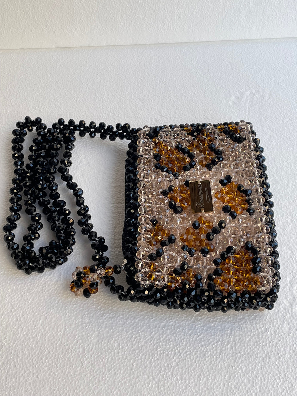 Bassmera Mini Savage – Rückansicht der Kristallperlentasche mit Leopardenmuster in Champagner, Karneol und Schwarz, goldfarbener Plakette und schwarzem Umhängeriemen