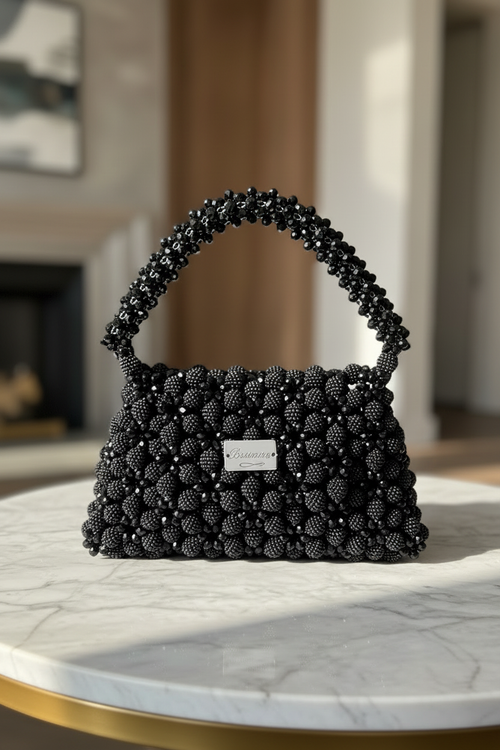 Black Bassmera beaded bag magnified on marble table